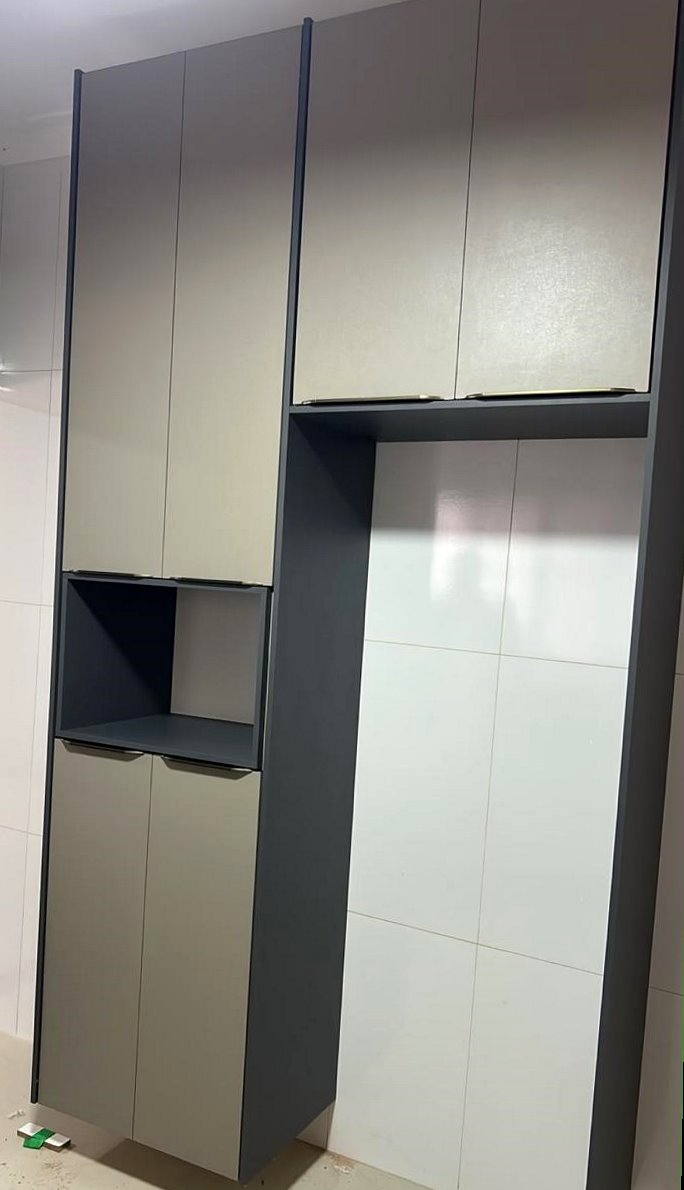 O mesmo sistema em outra casa: torre alta com frentes em marfim, estrutura grafite e nicho no meio, numa cozinha